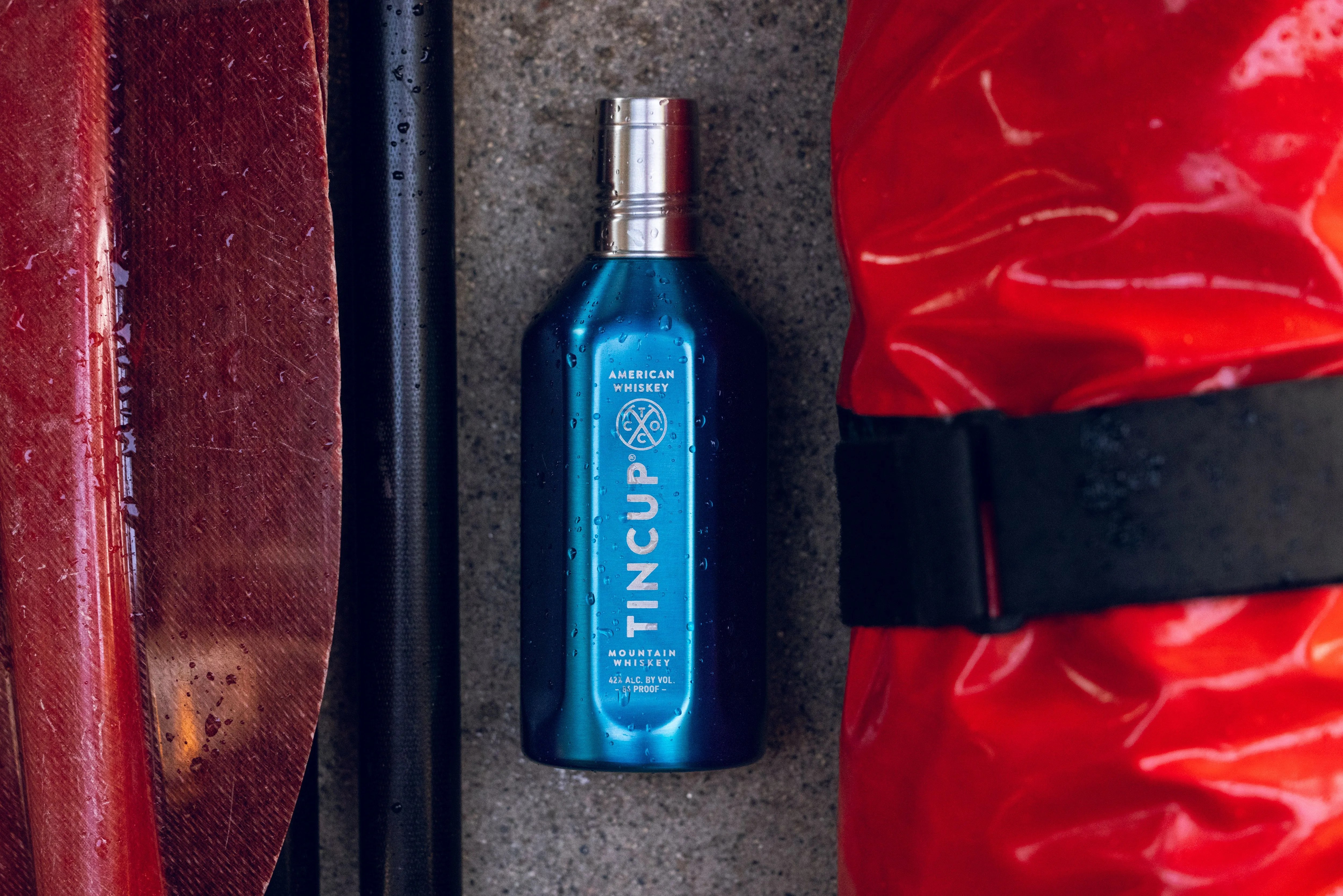 tincup whiskey can laying between paddle and boat