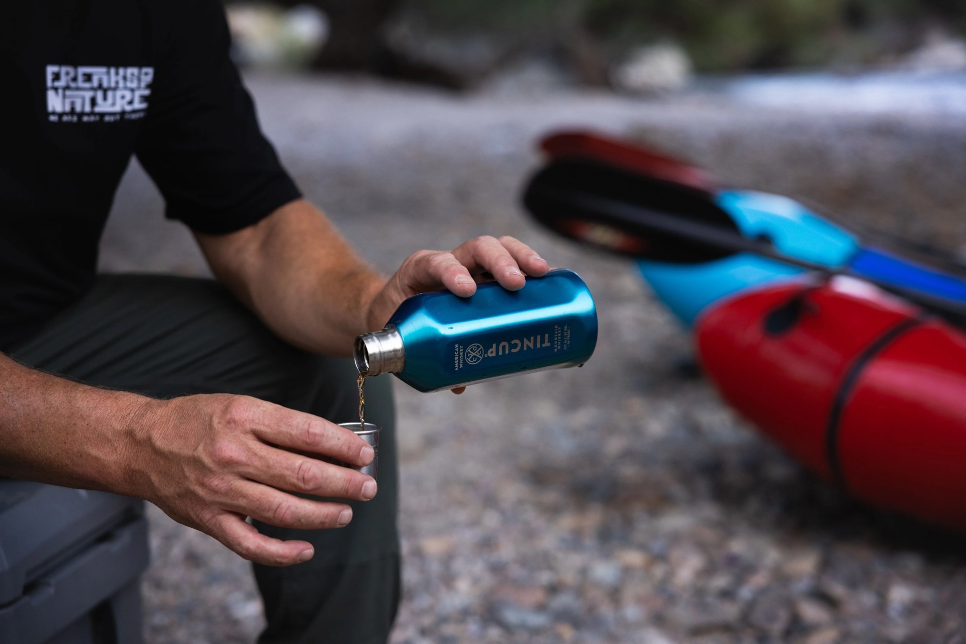 man pouring tincup whiskey for himself