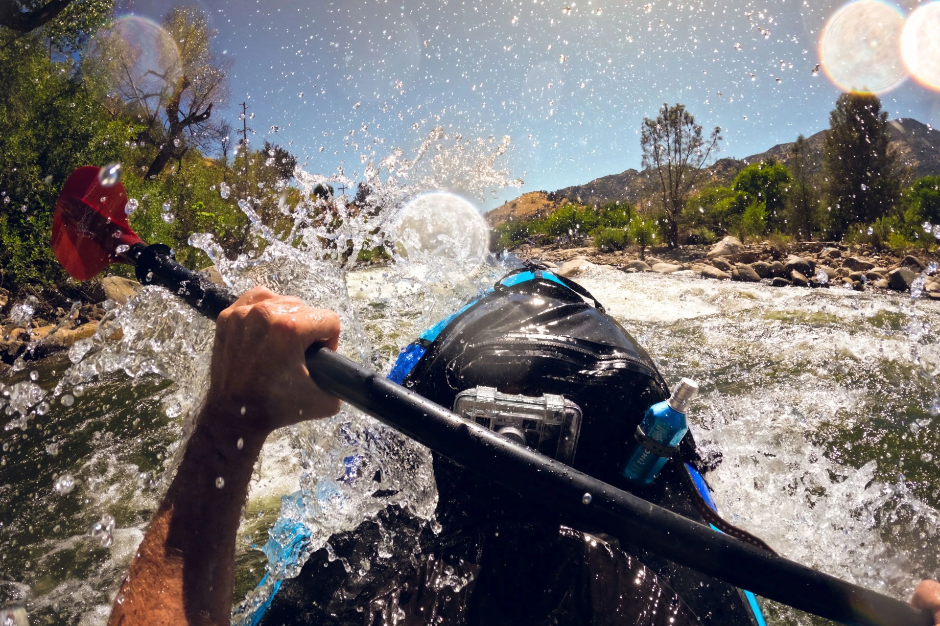 man paddling against current of river with tincup whiskey