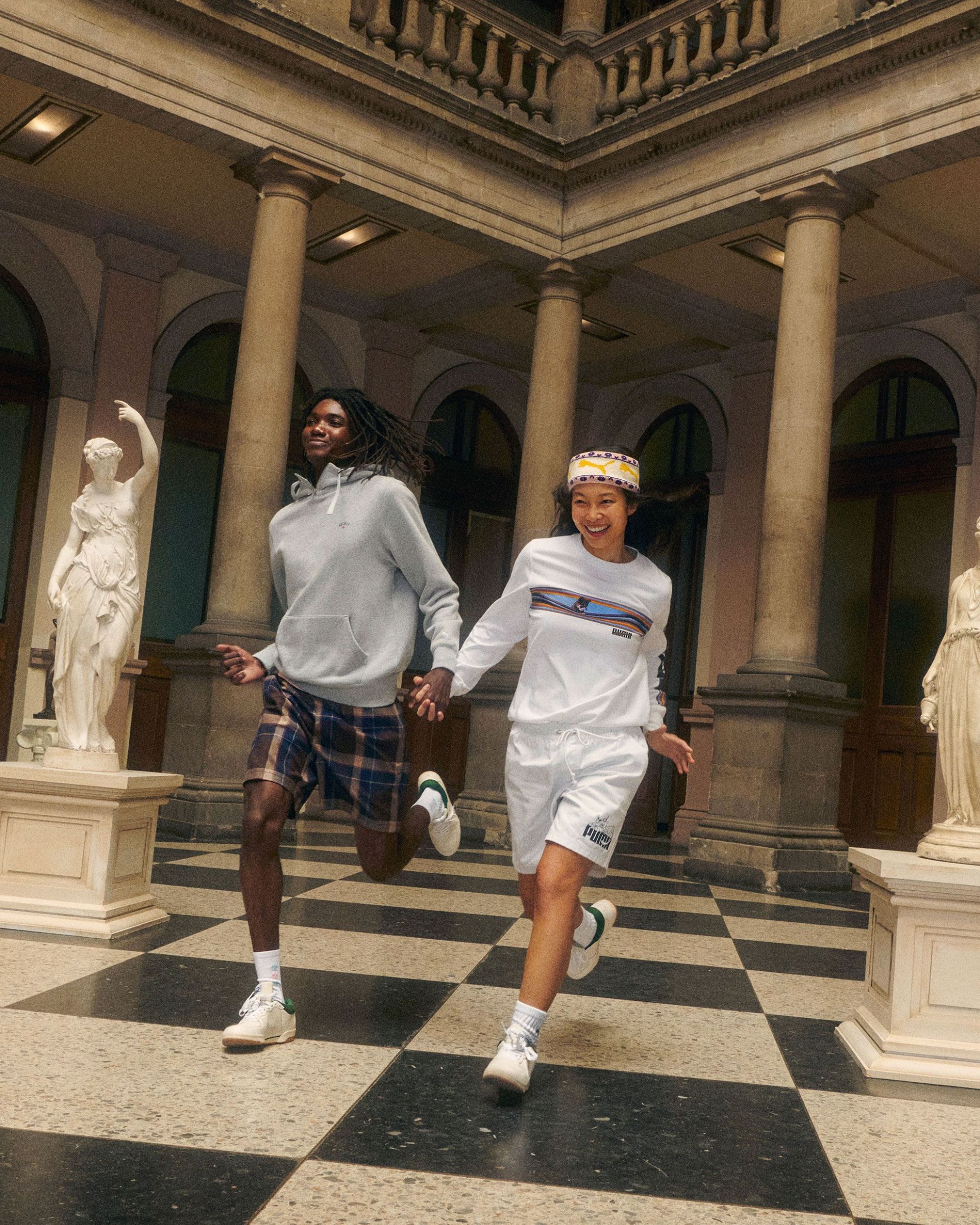 woman and man running through art museum wearing noah x puma collection