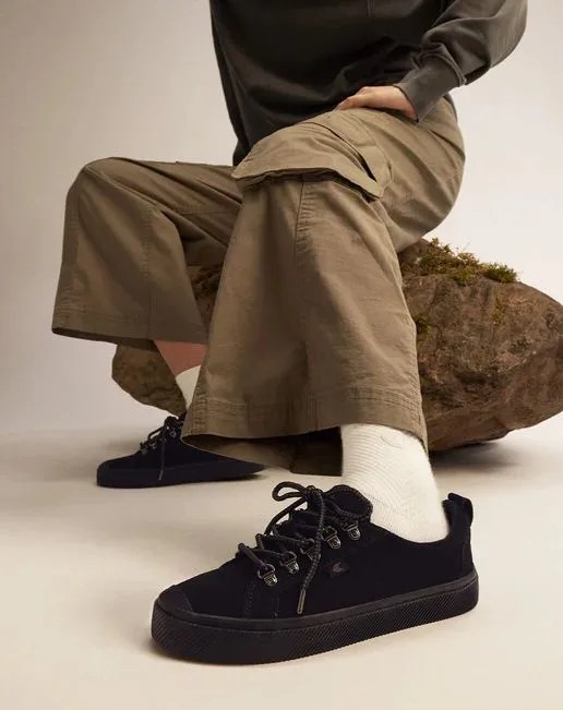 person wearing cariuma speed hooks all black suede