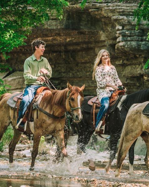three people horseback riding through dogwood canyon nature park