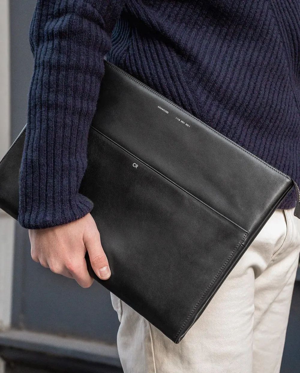man holding grams leather folio