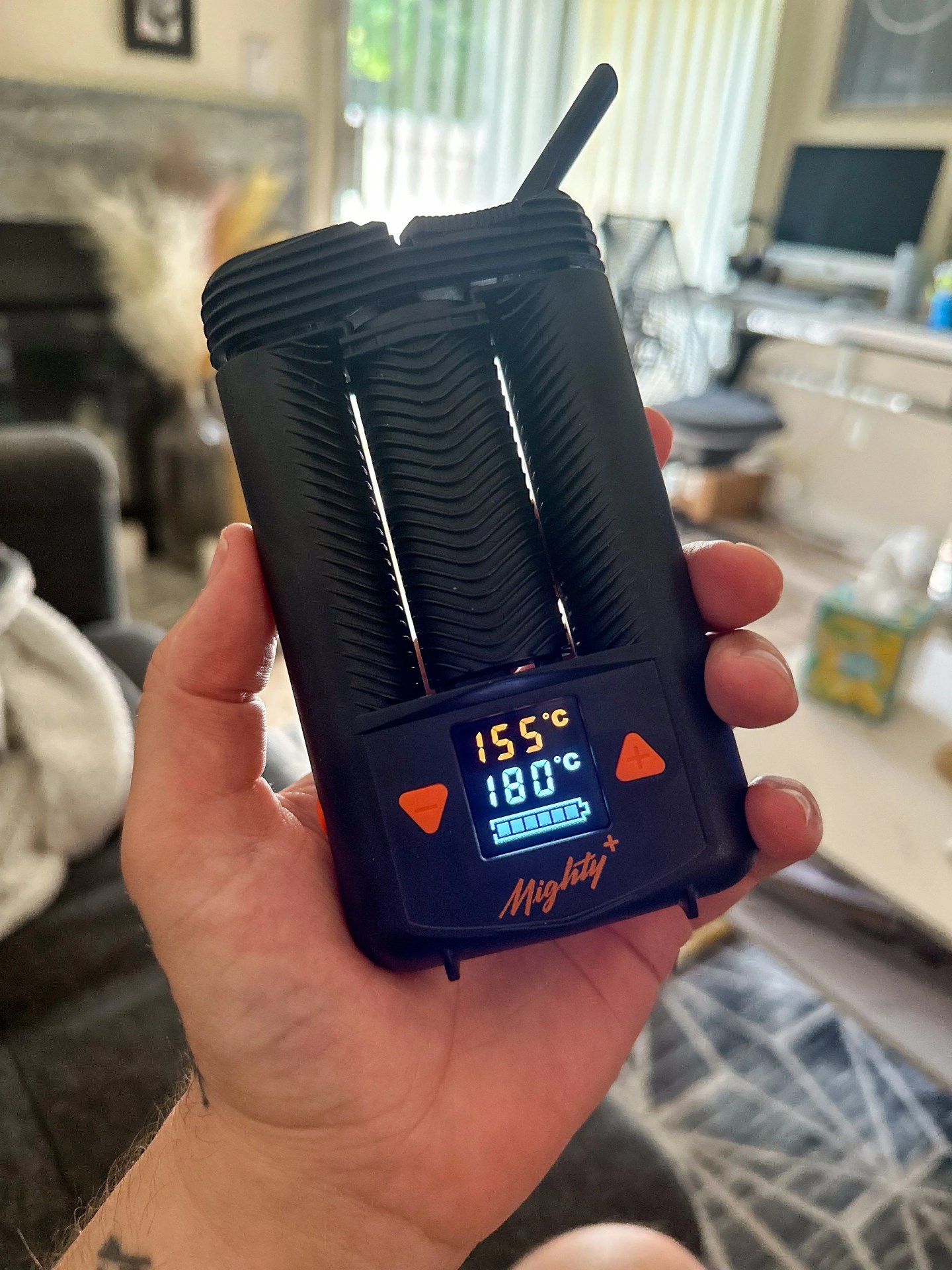 a person holding a mighty plus weed vape