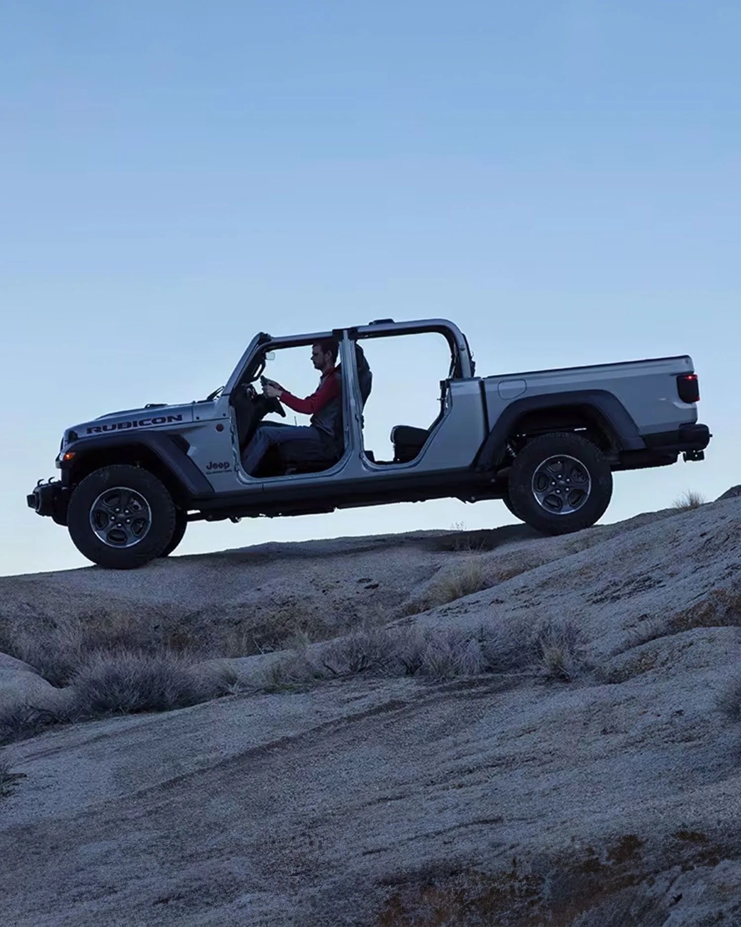 man driving jeep gladiator across rocky terrain