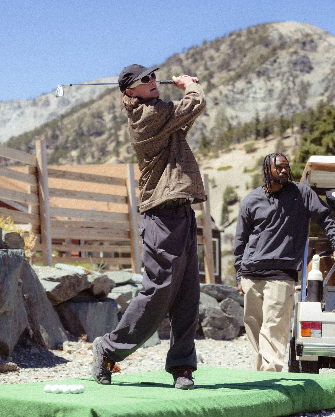 a person playing a game of golf wearing 686 x malbon everywhere merino lined golf pant