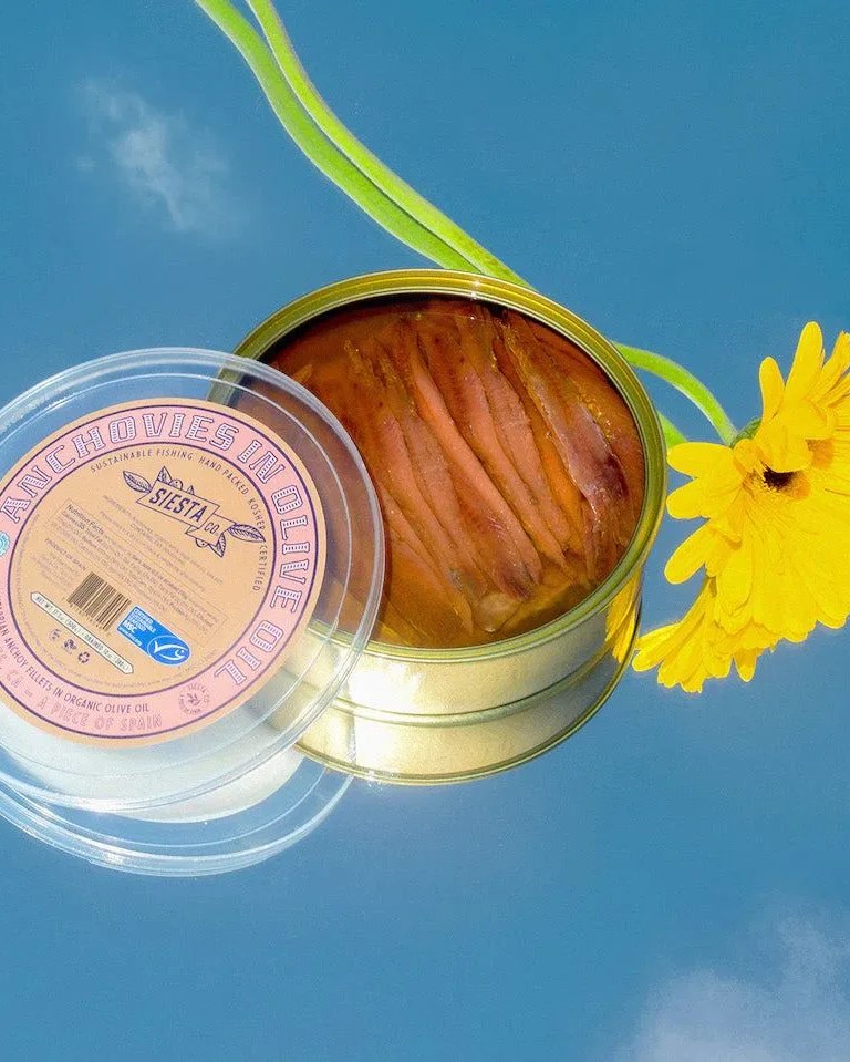 cantabrian anchovies in organic extra virgin olive oil next to a yellow flower