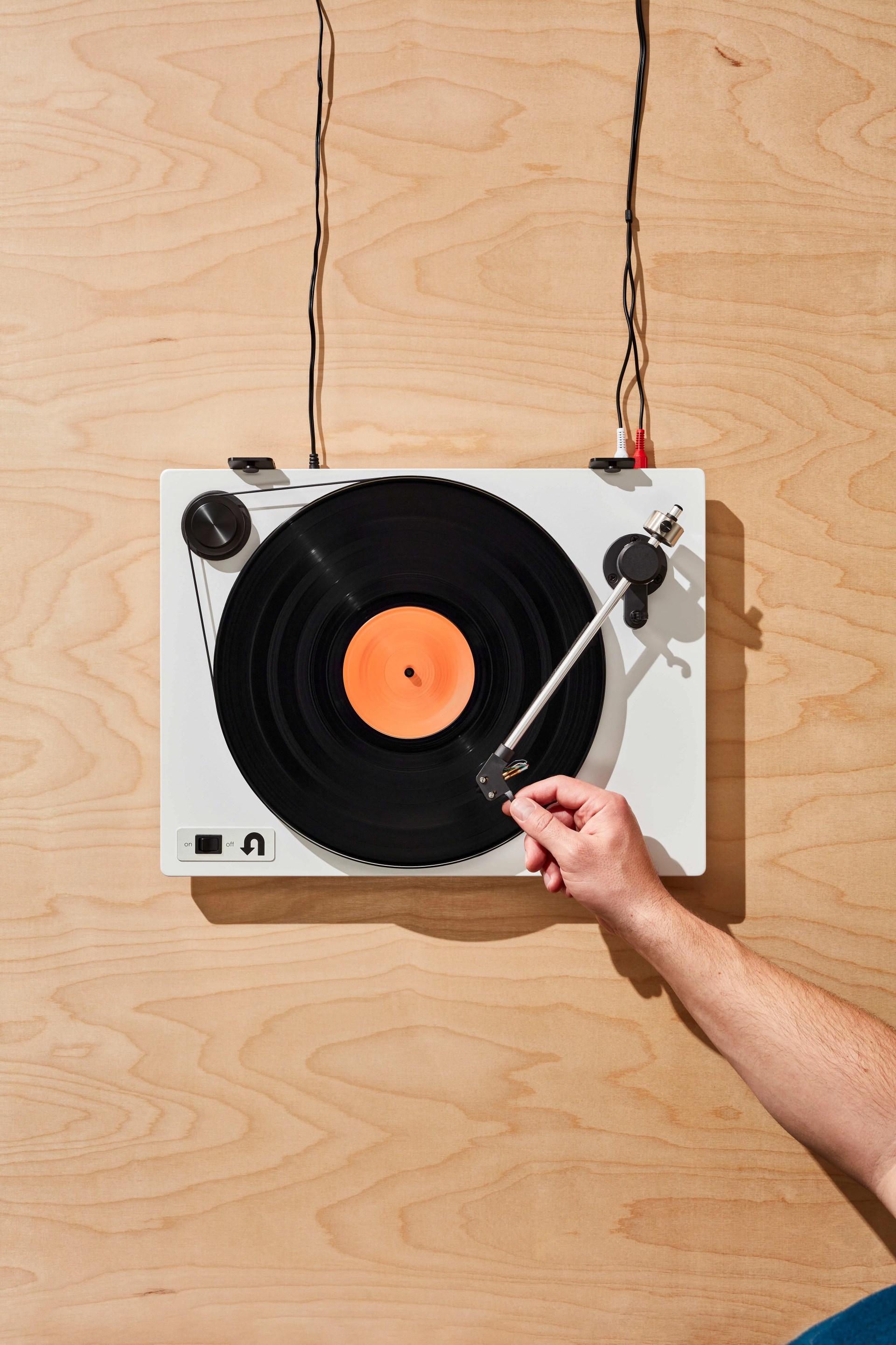 a hand putting on a record on a turntable