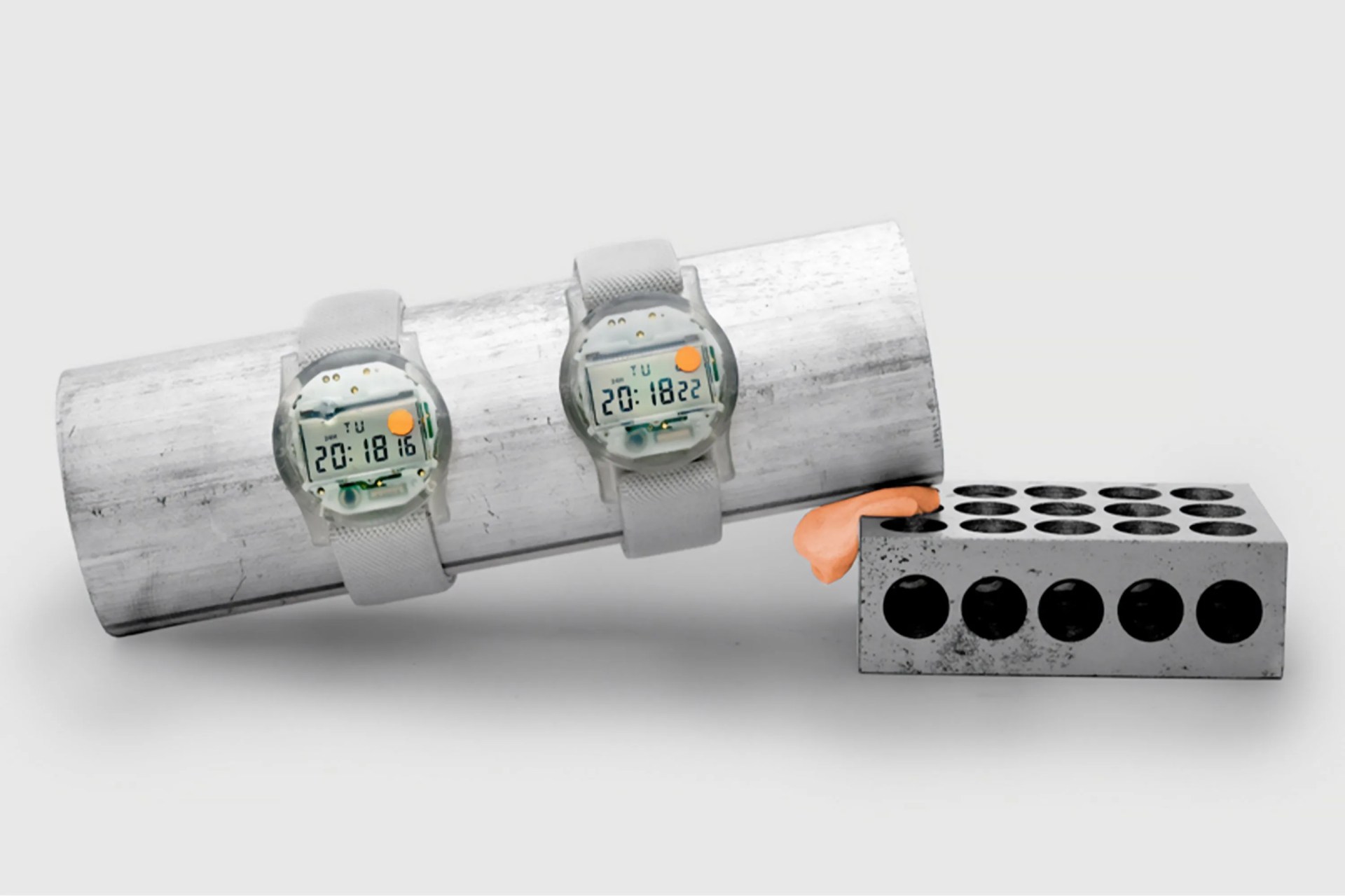 two watches on a concrete block