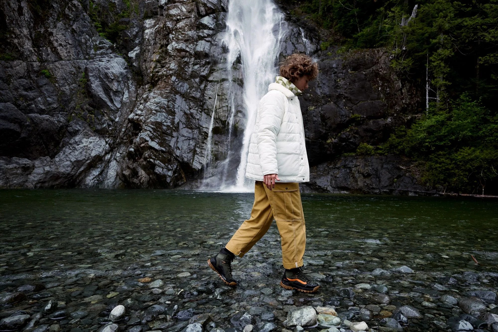 a man standing in front of a waterfall