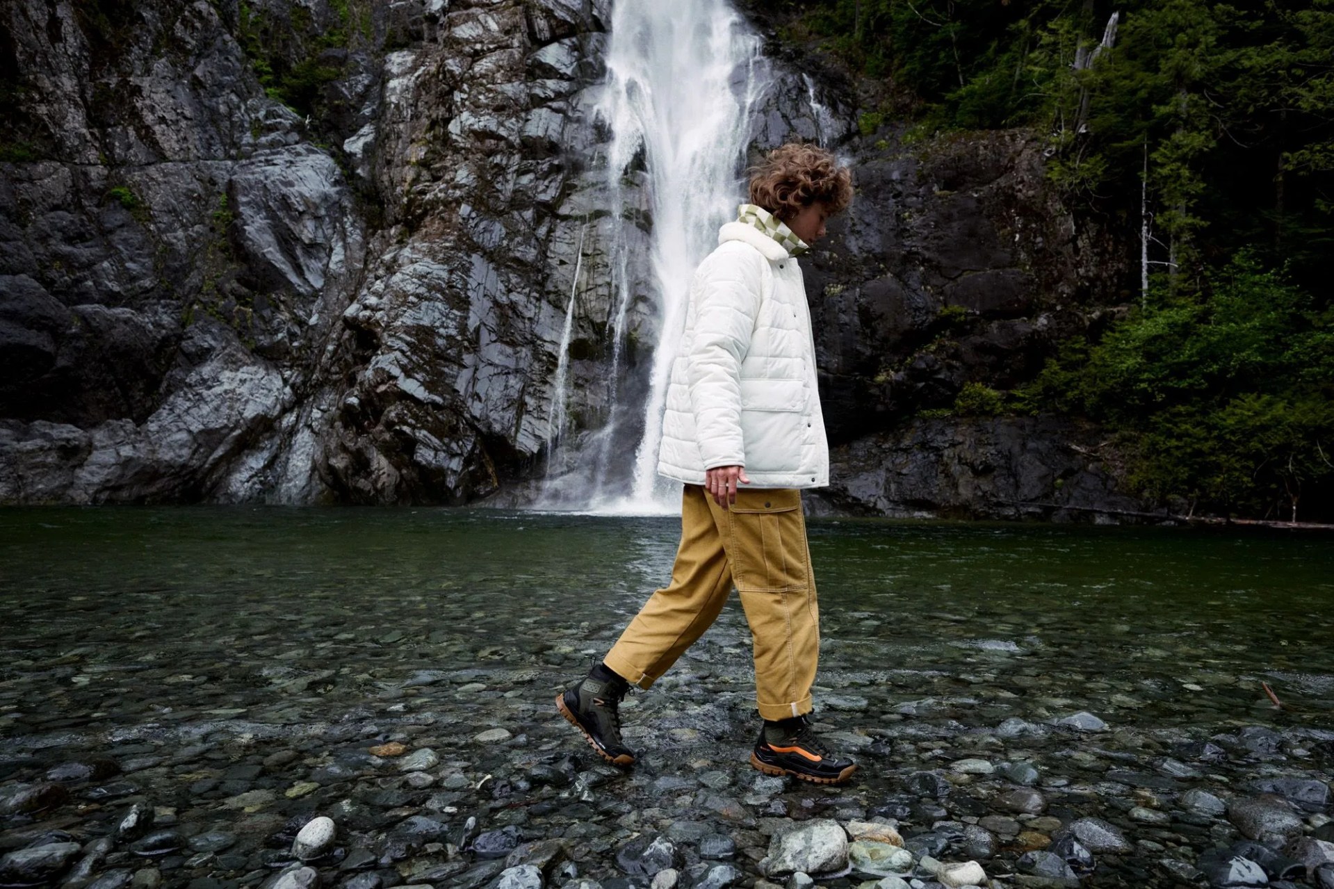 a man standing in front of a waterfall