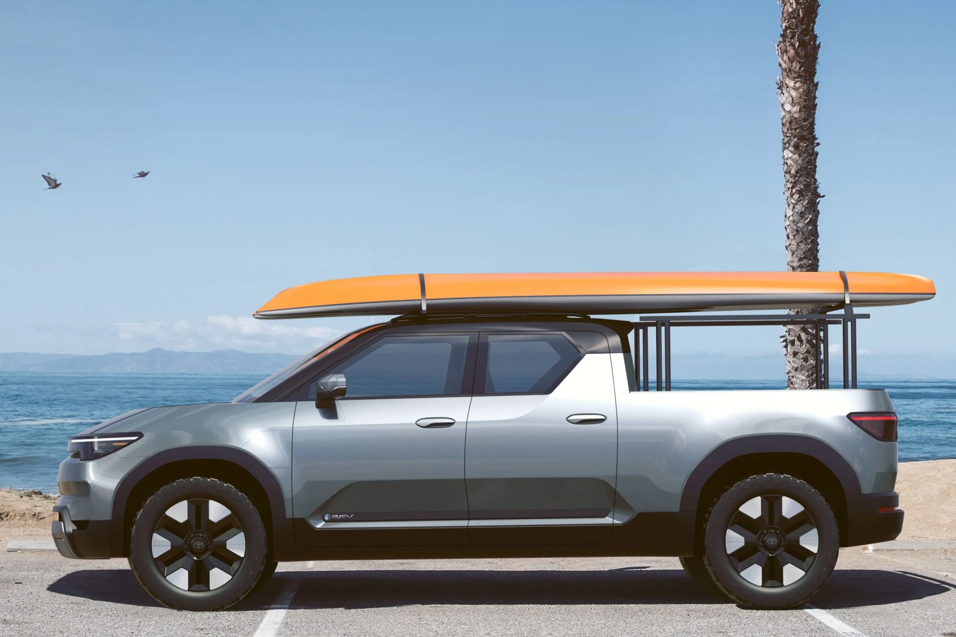 toyota electric pickup with surfboard on the roof