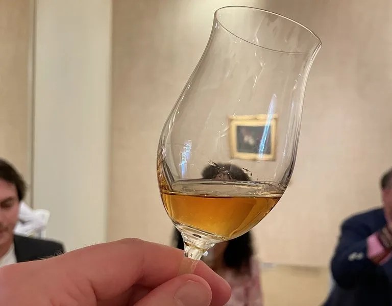 a person holding a glass of whisky