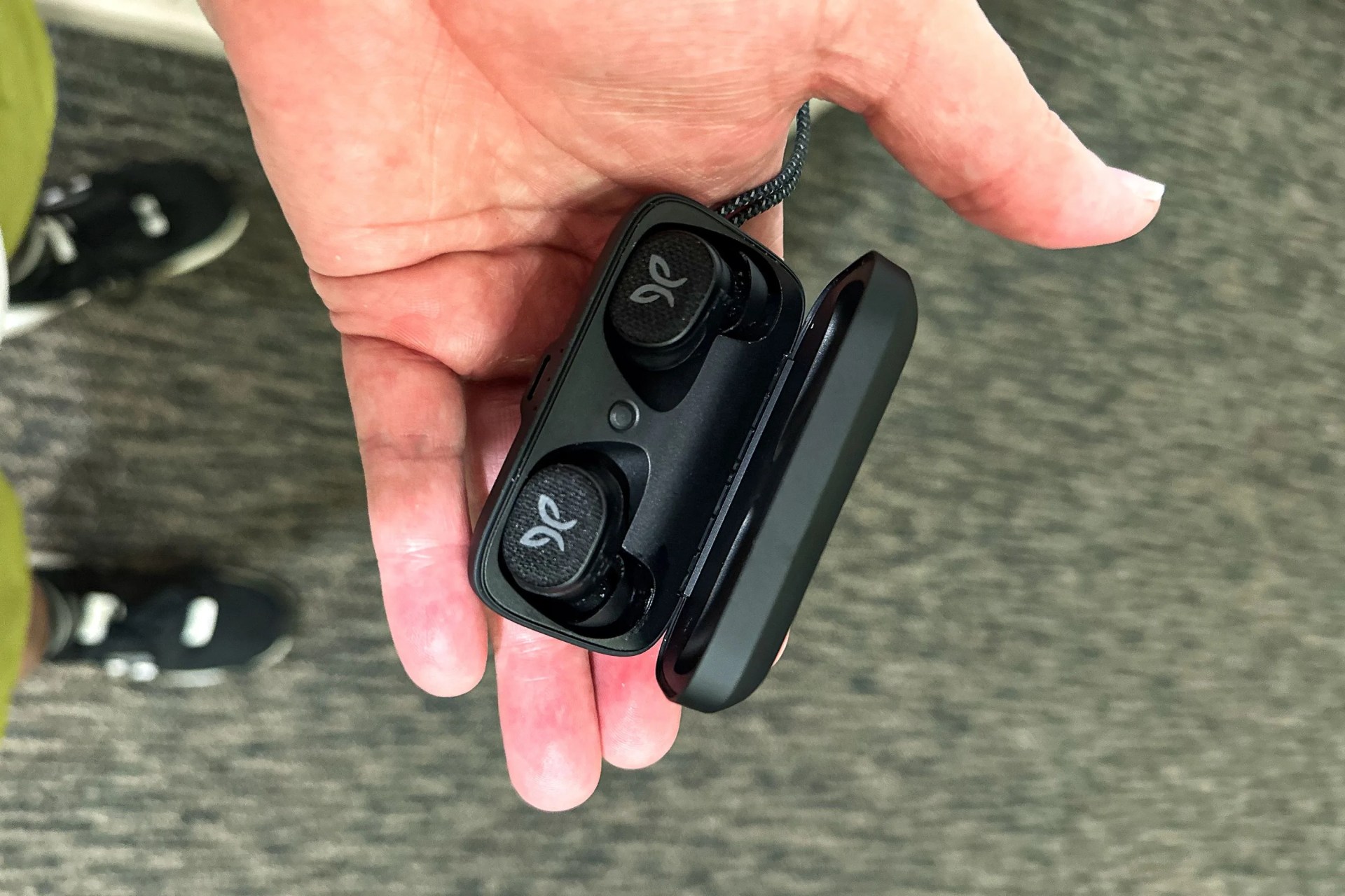 a hand holding earbuds