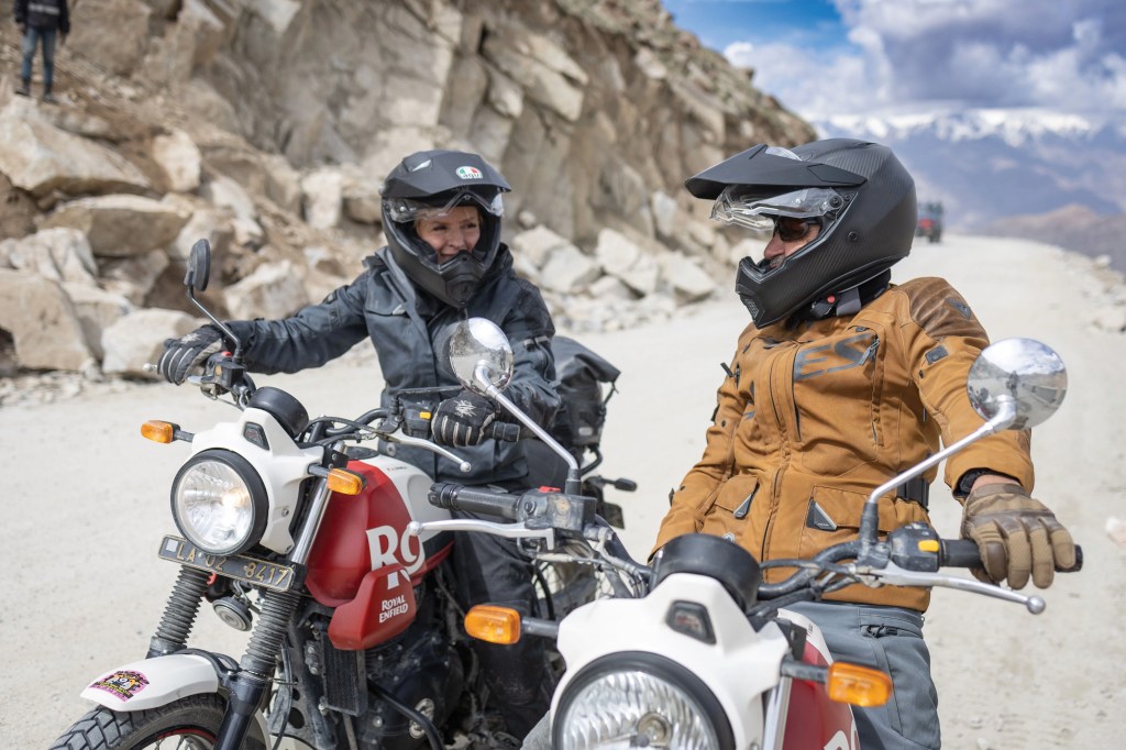 two people talking to each other on motorcycles