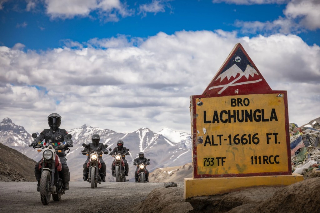 a group of people on motorcycles by a sign