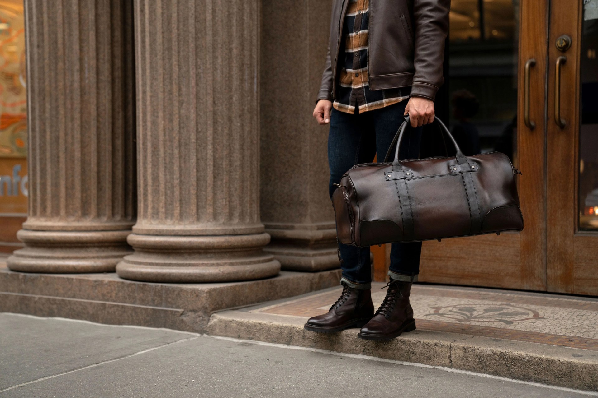 a person carrying a thursday boot co duffel bag