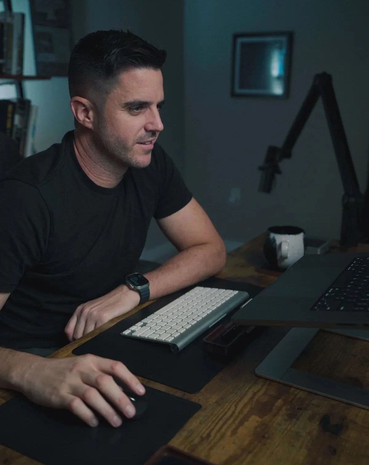 a man sitting at a desk with a computer using leander mouse pad