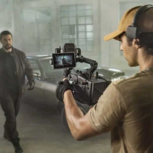 a person wearing a helmet and holding a dji ronin 4d 4 axis cinema camera