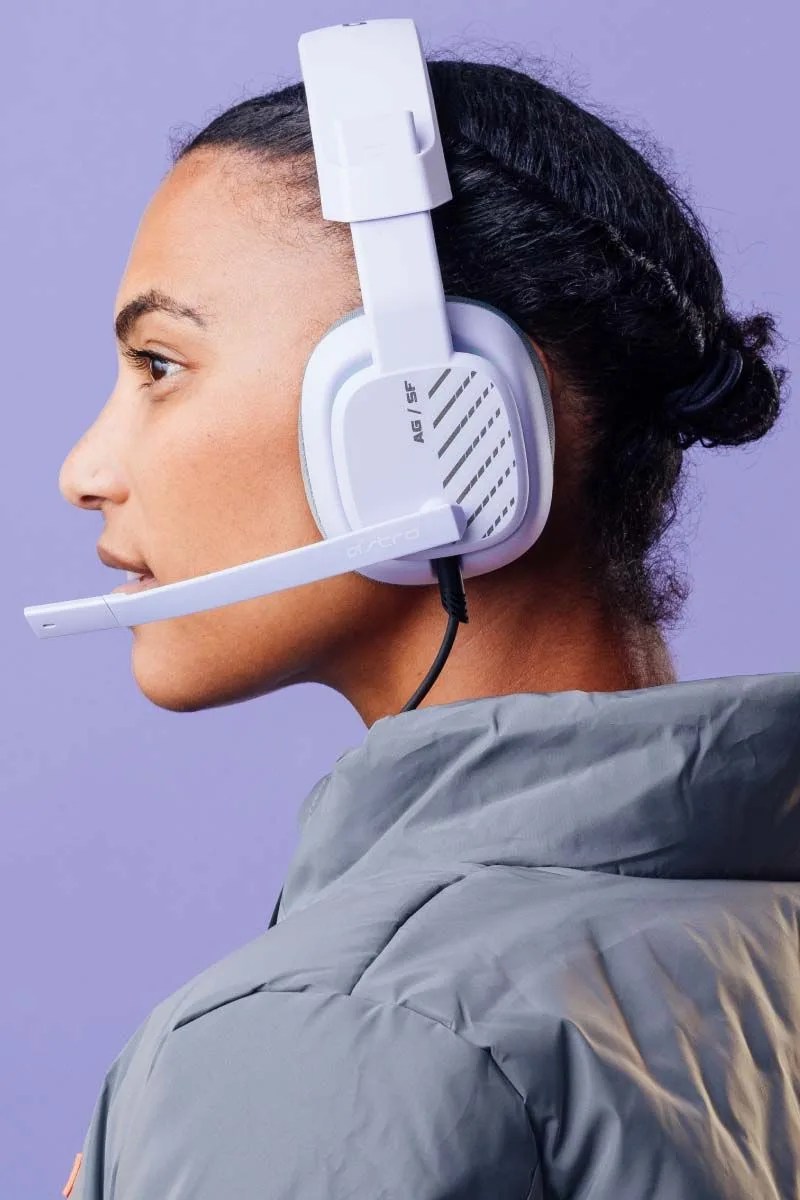 a person wearing logitech astro a50 x headphones in white