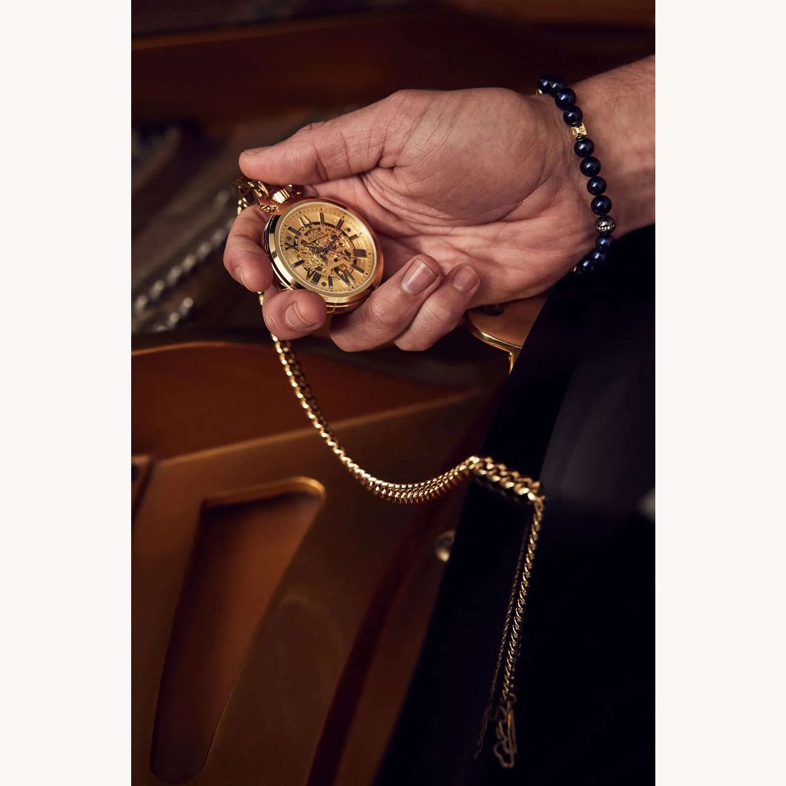 a person holding a bulova sutton pocket watch