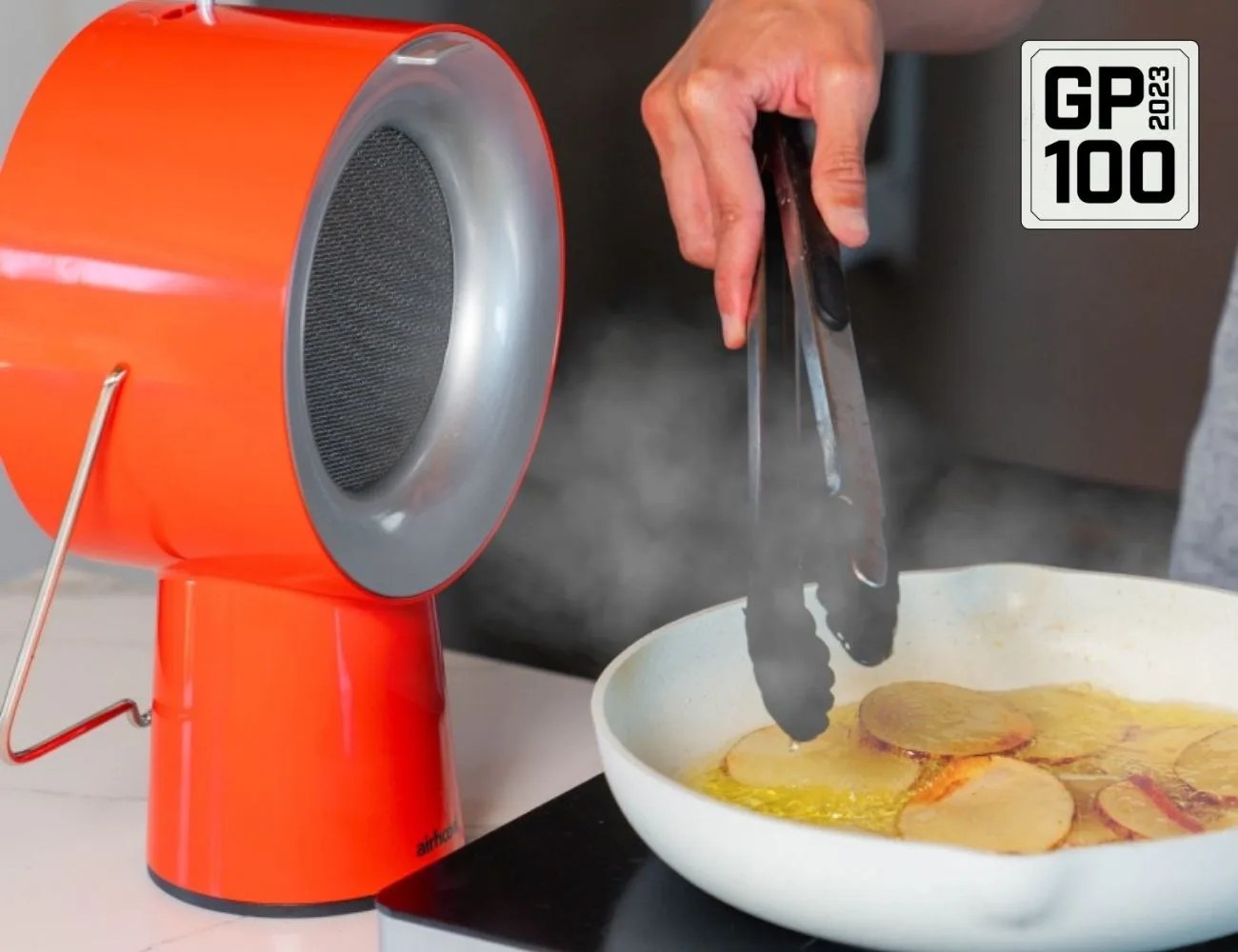 a person cooking sliced potatoes on a stove next to a fan