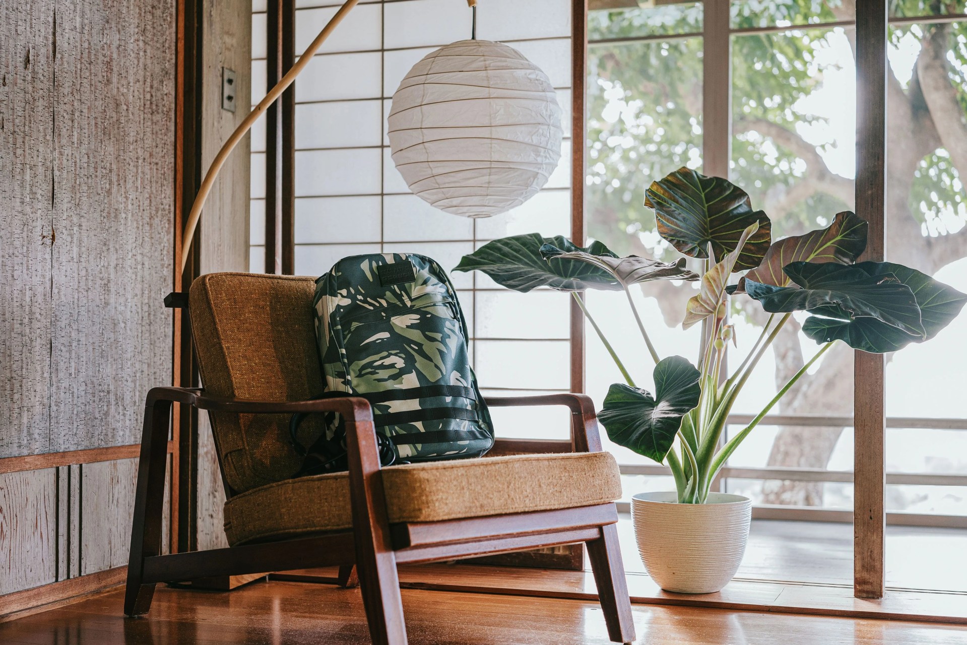 goruck bag on chair next to plant and underneath a white circular lamp
