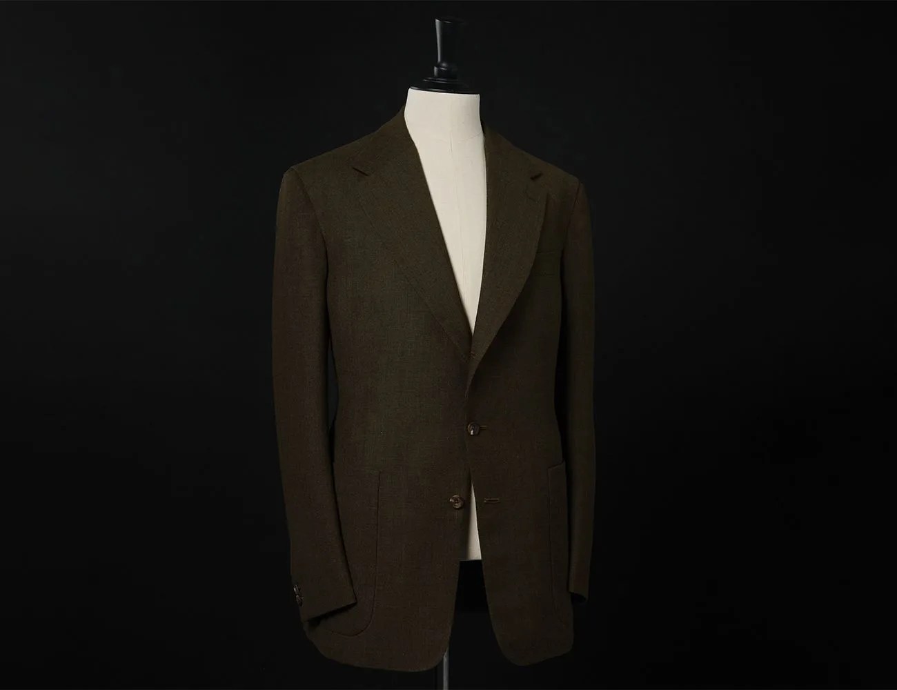 a suit on a mannequin with a black background