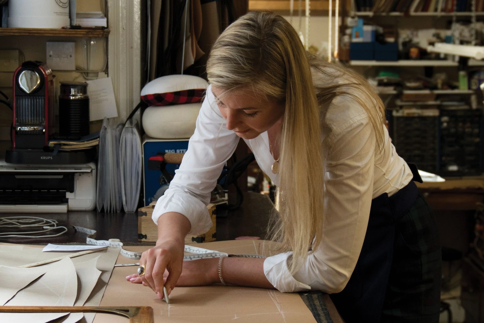 caroline andrew works on a pattern on her sewing table