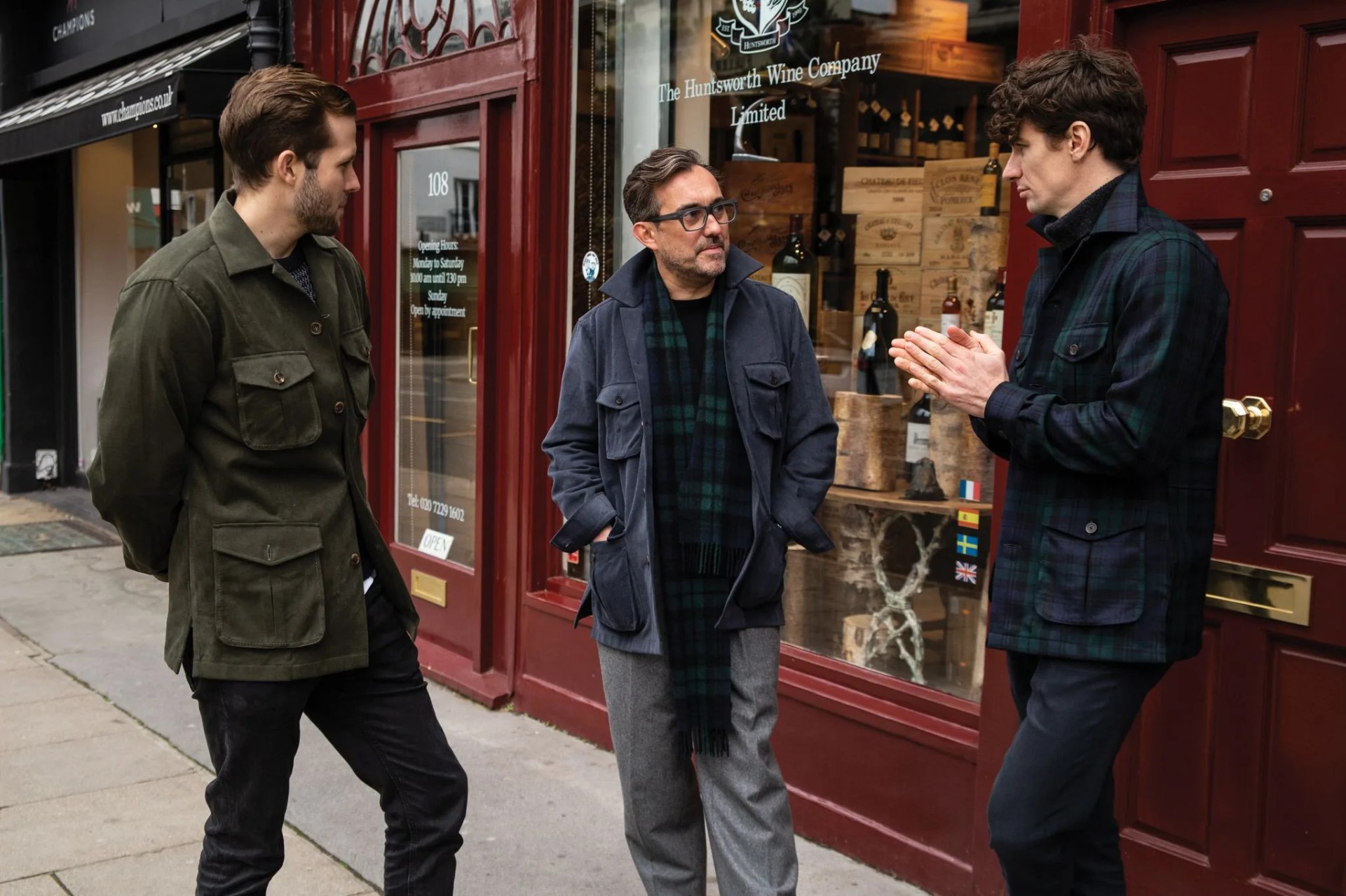 a group of men talking to each other outside of a shop