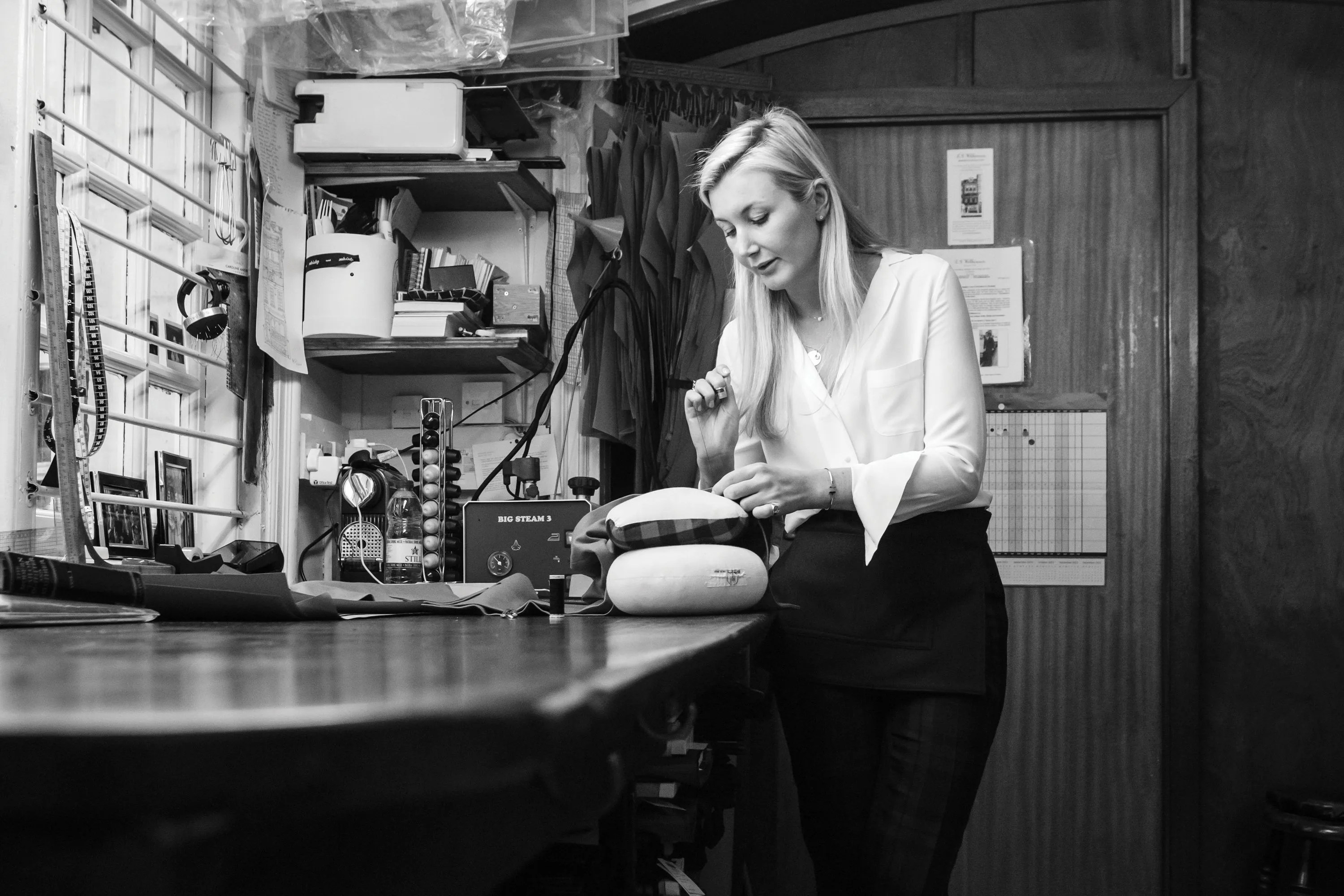 a woman sewing standing next to a counter