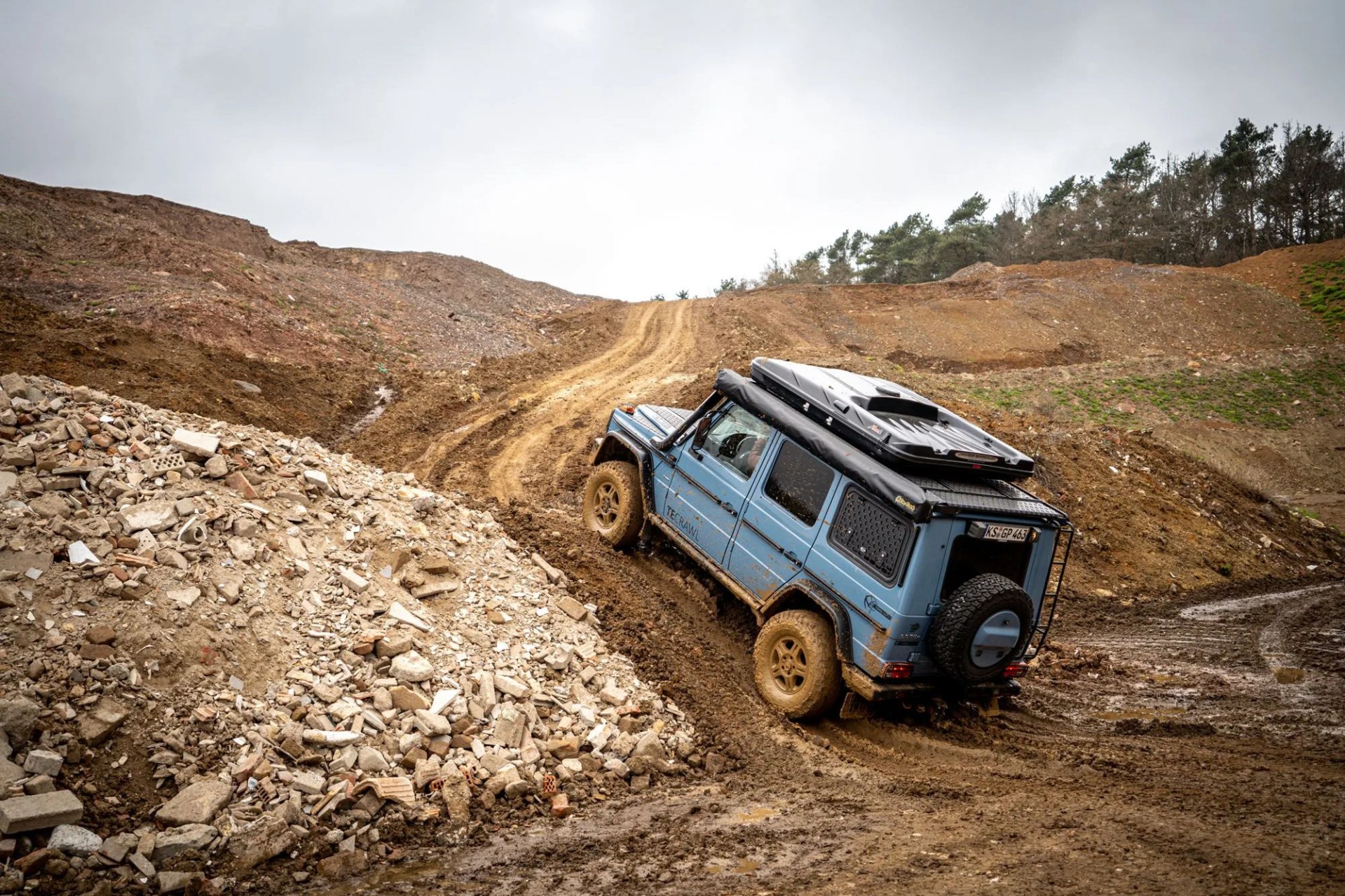 a blue car on a rocky road