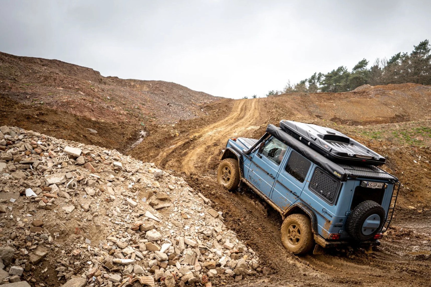 a blue car on a rocky road