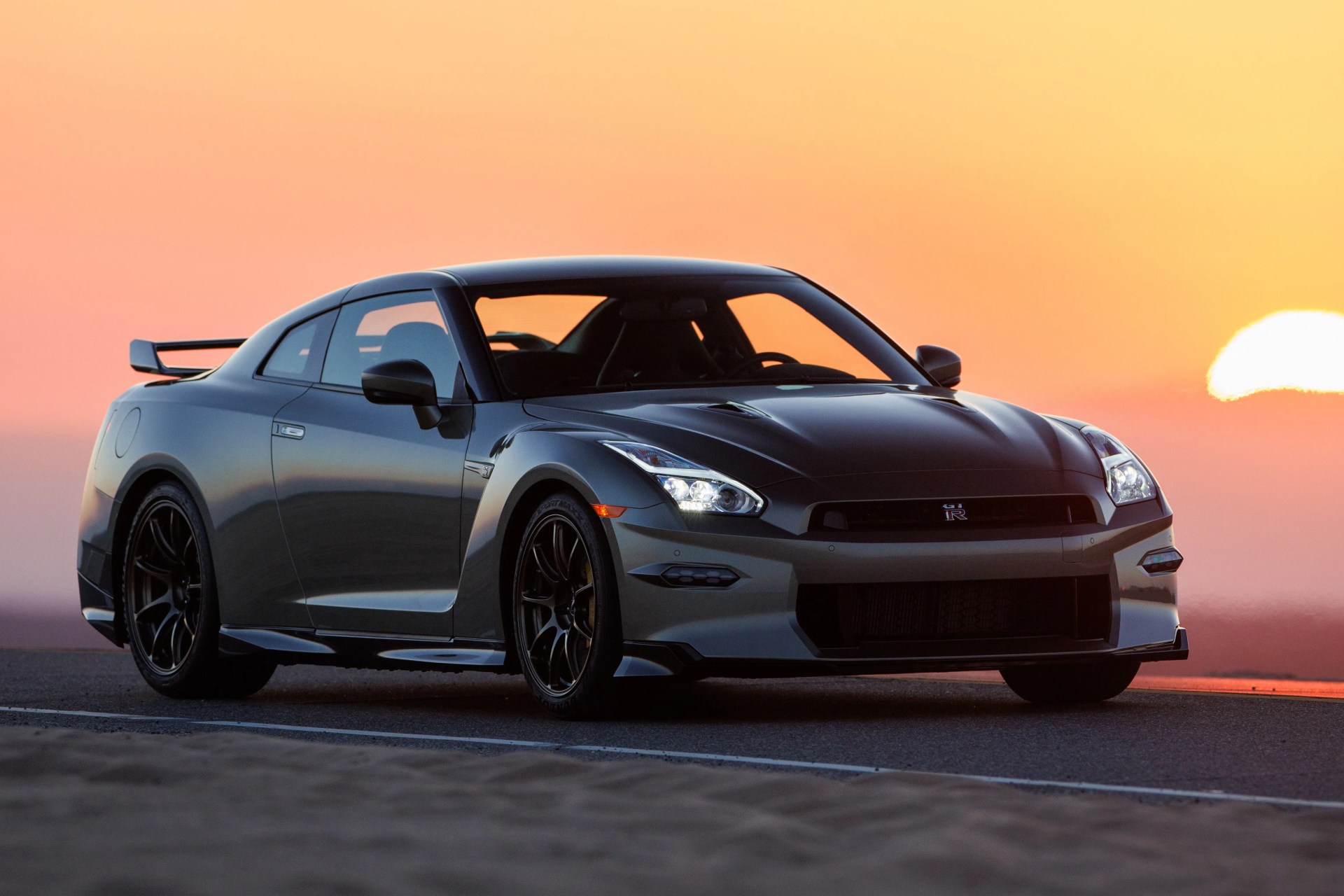 a car on a road in front of a sunset