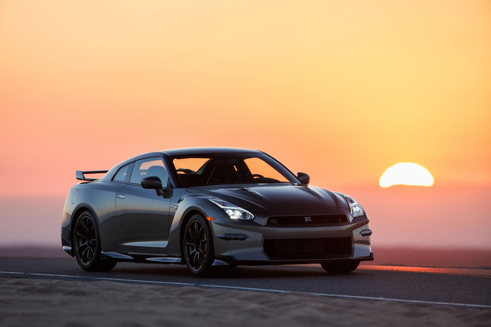 a car on a road in front of a sunset