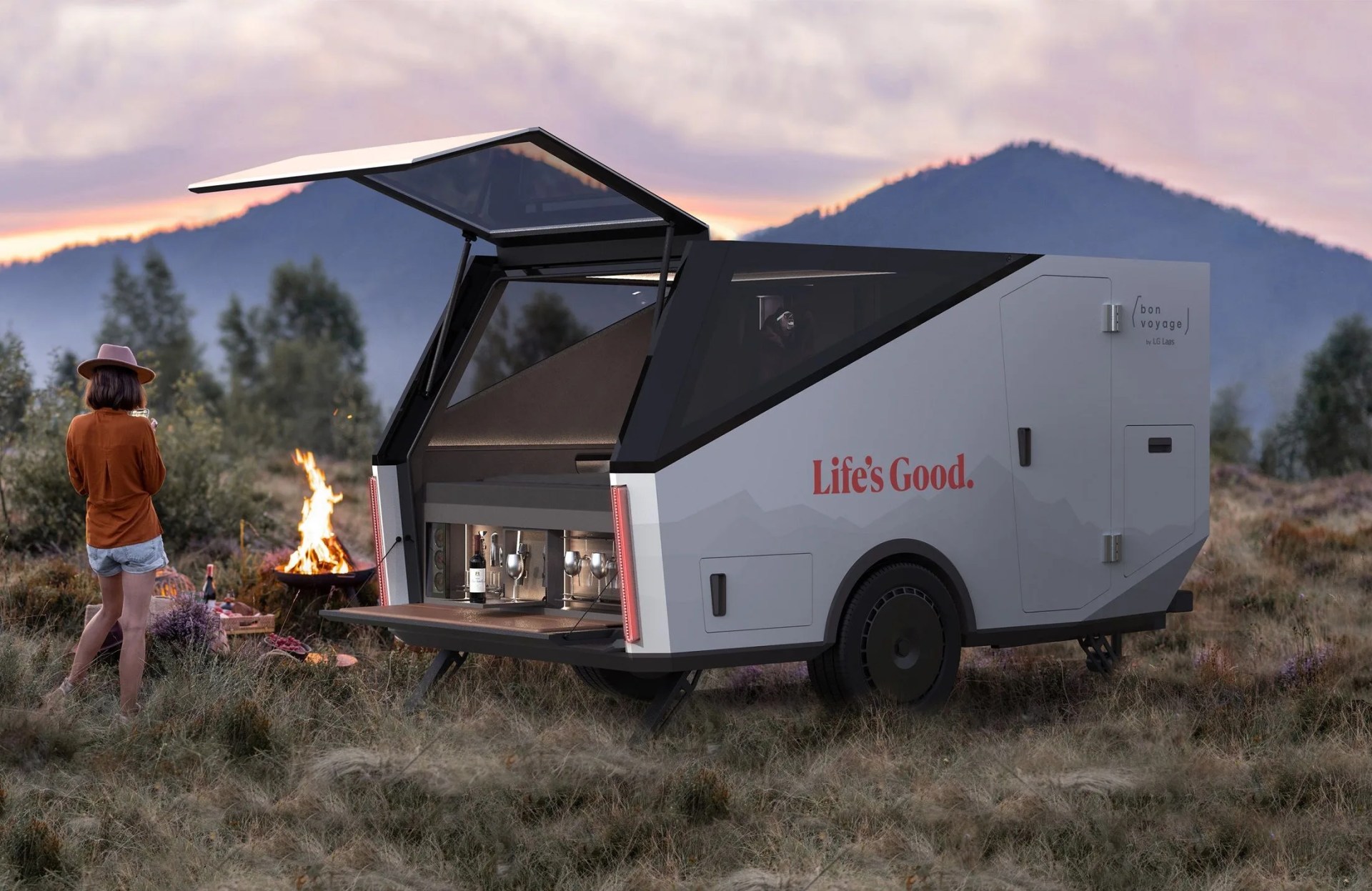 a person standing next to a camper with a fire in it