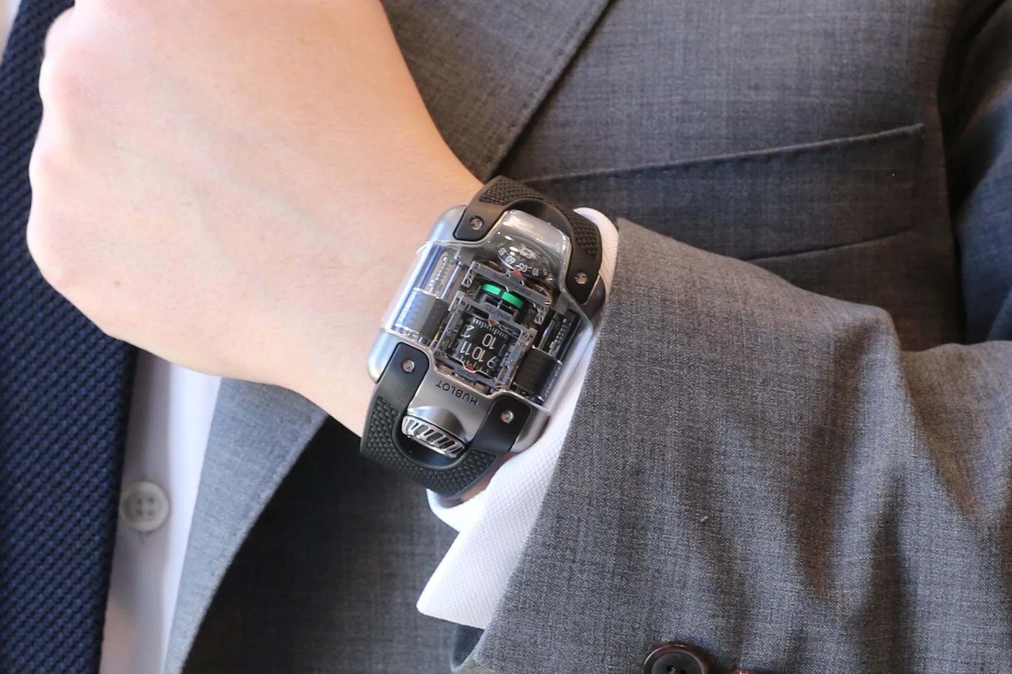 man in a suit wearing a crazy watch