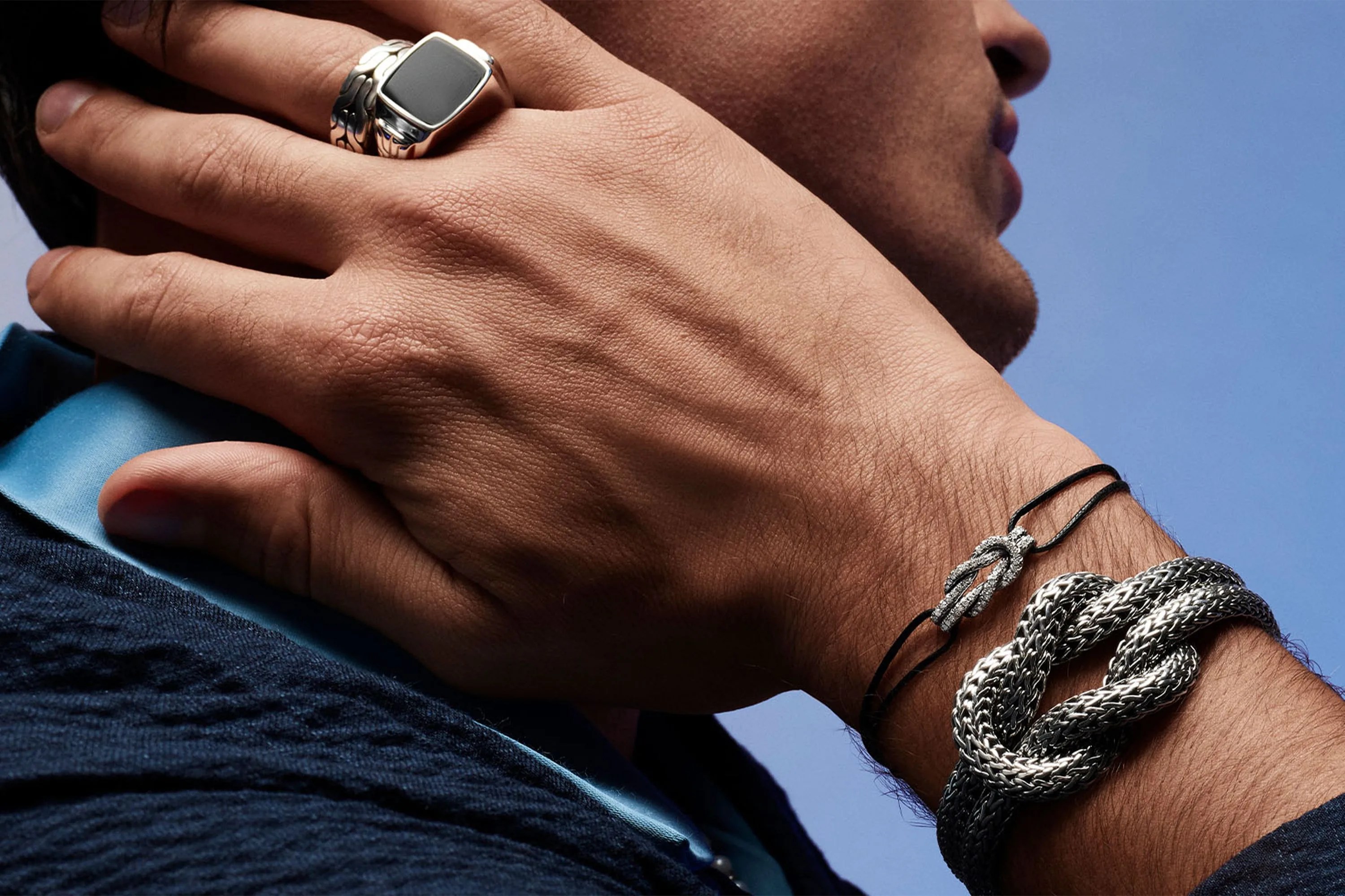 a close up of a man wearing jewelry