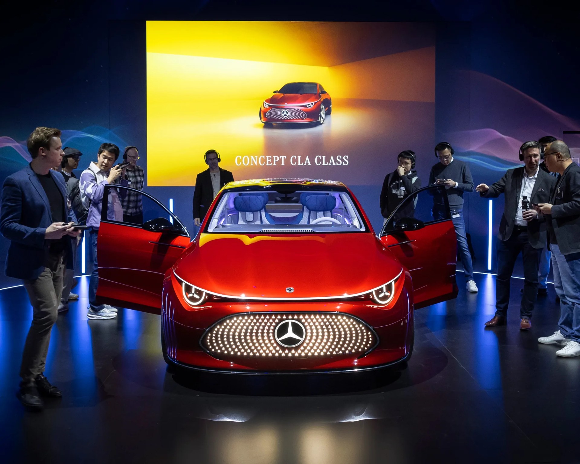 a crowd of people standing around and looking inside the mercedes benz concept cla class with its doors open