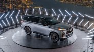 Infiniti QX80 on a lit platform at night