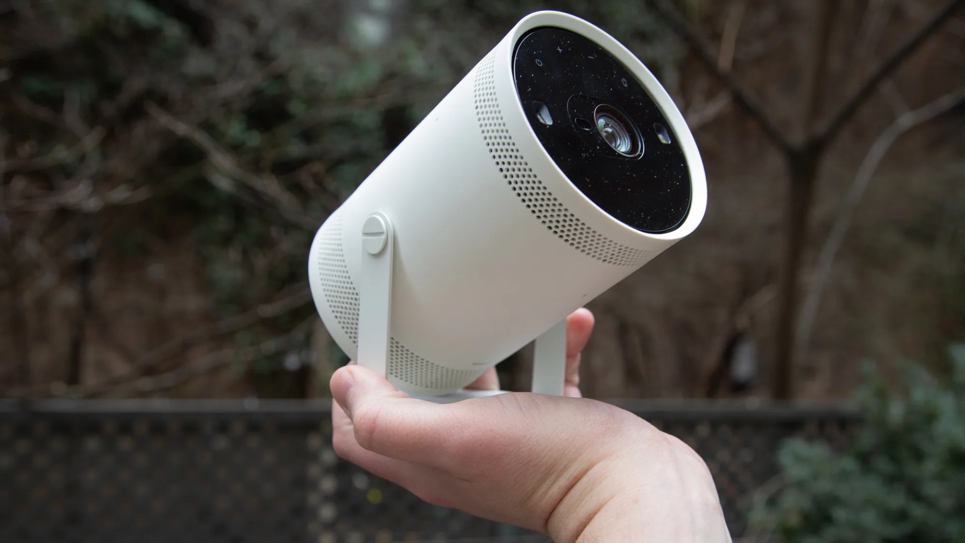 white samsung freestyle portable projector being held in hand