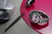tudor pink watch lies on a pink mat on a table