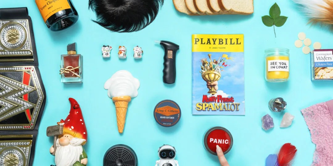 An assortment of random items including an ice cream cone, a playbill, a garden gnome and a WWE championship belt on a light blue background