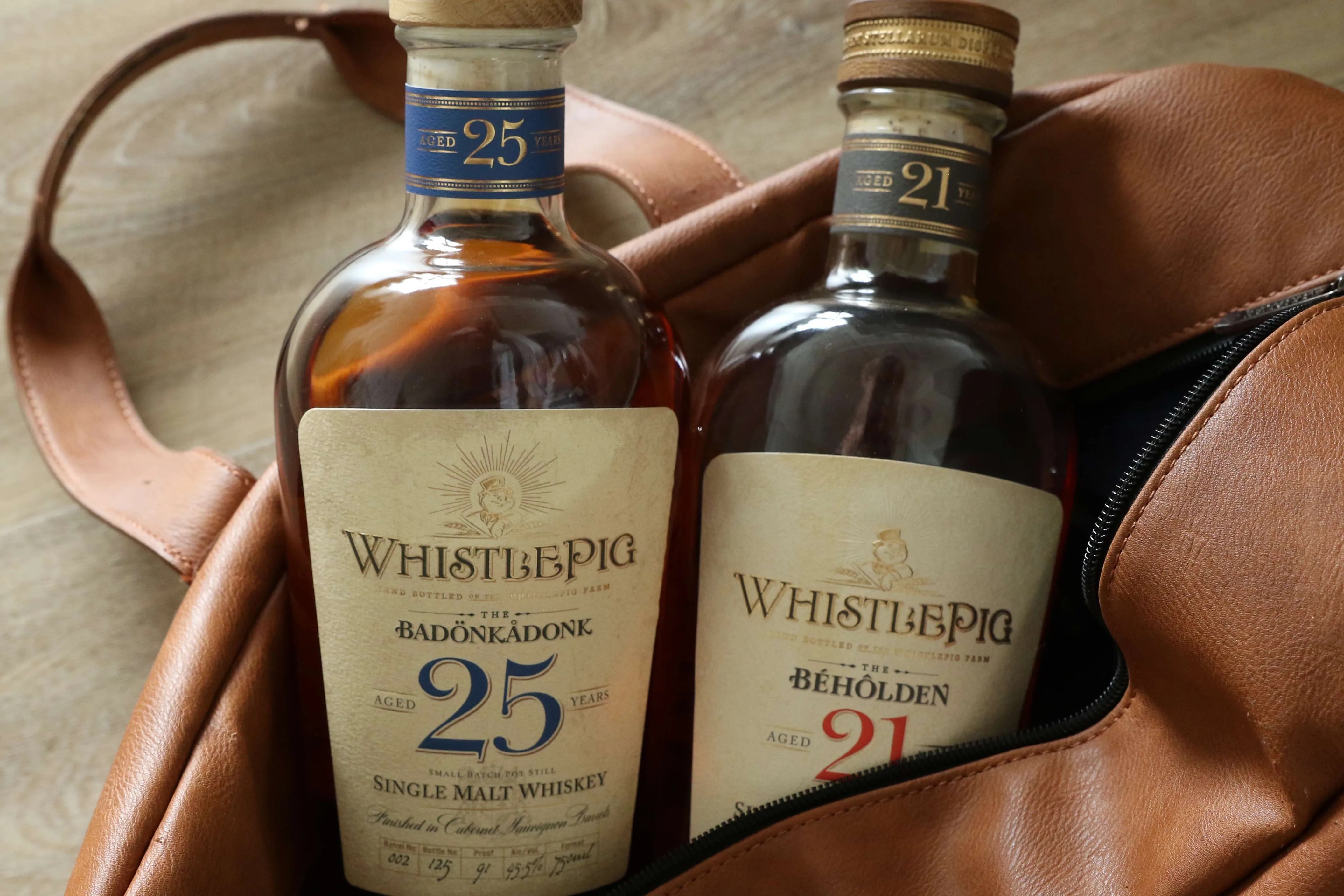 two bottles of whistlepig whiskey in a duffel bag