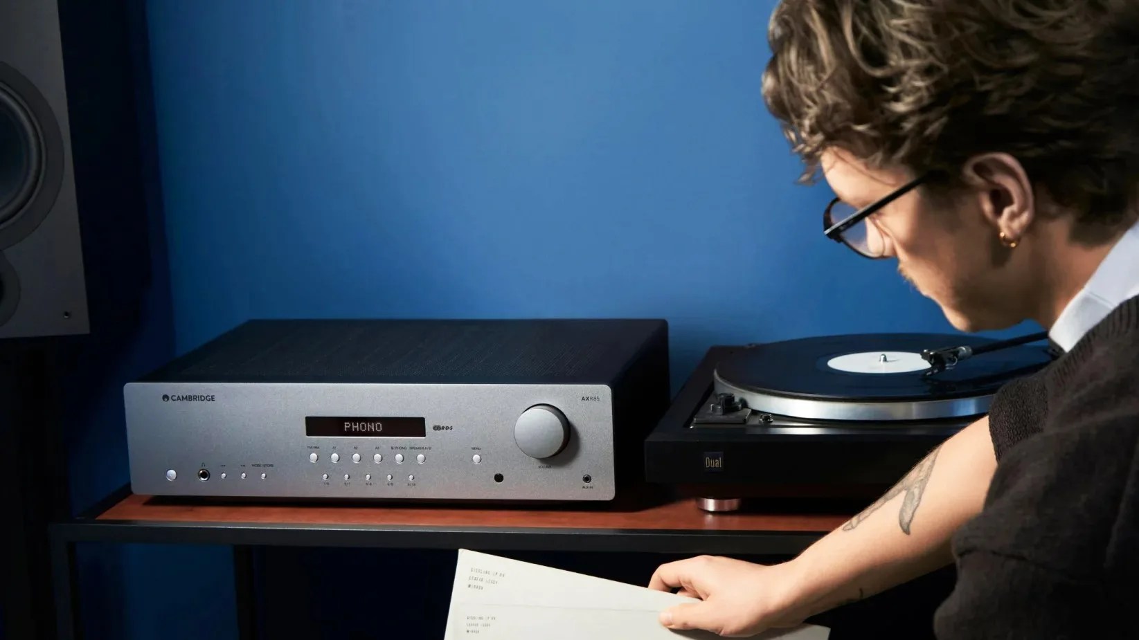 man in a blue room with stereo receiver behind him