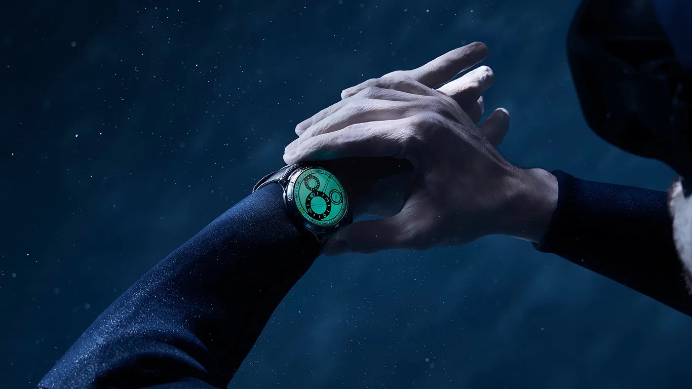 a diver wearing a luminous ressence dive watch underwater