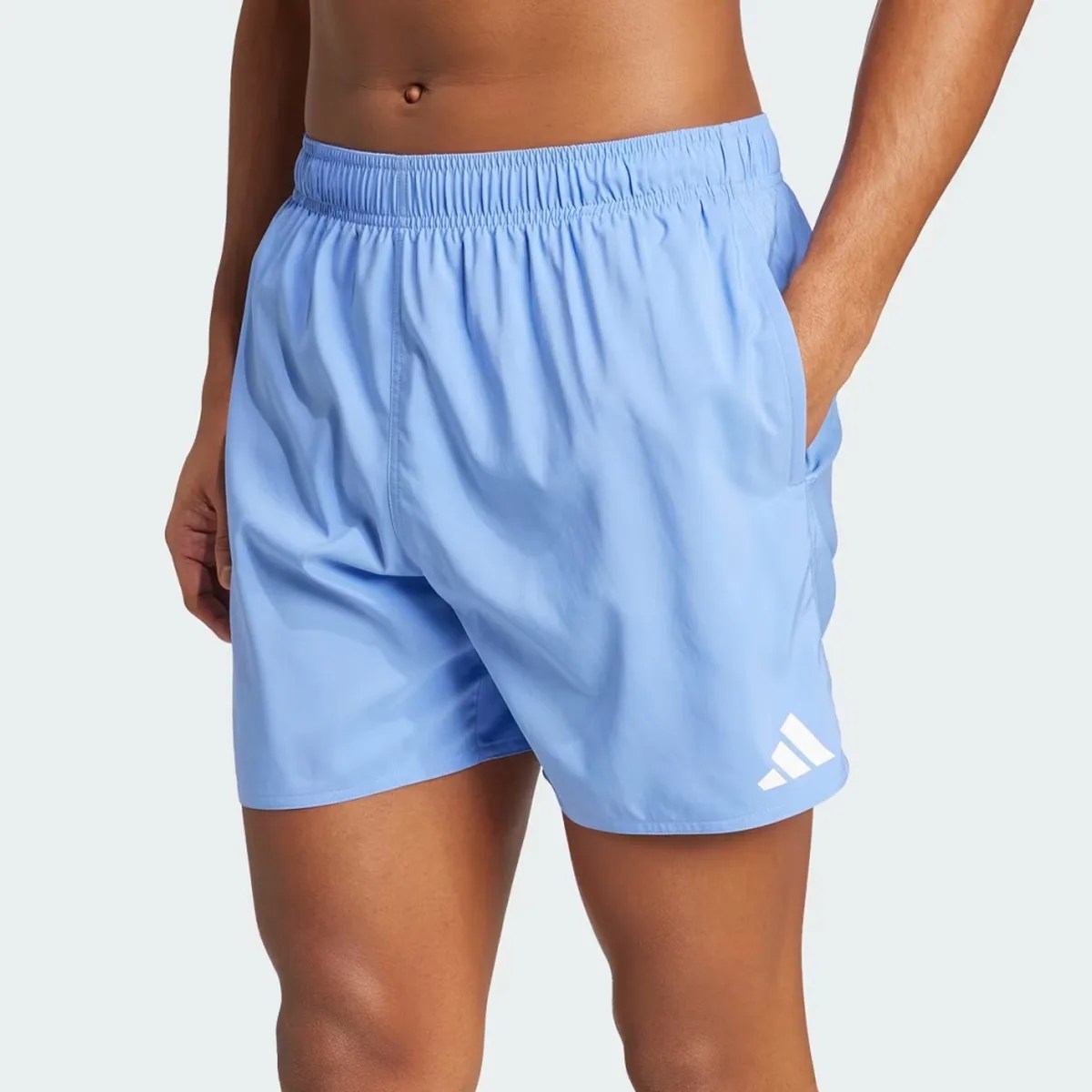 Light blue athletic shorts with elastic waistband and white Adidas logo on left leg, worn by a person.