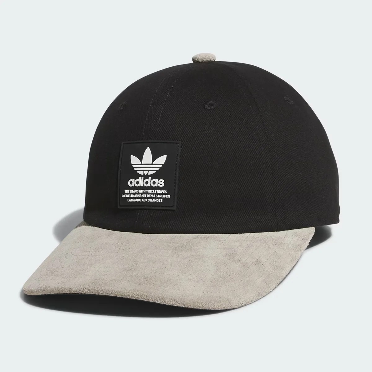 Black Adidas cap with a beige suede curved brim and a black patch logo on the front.