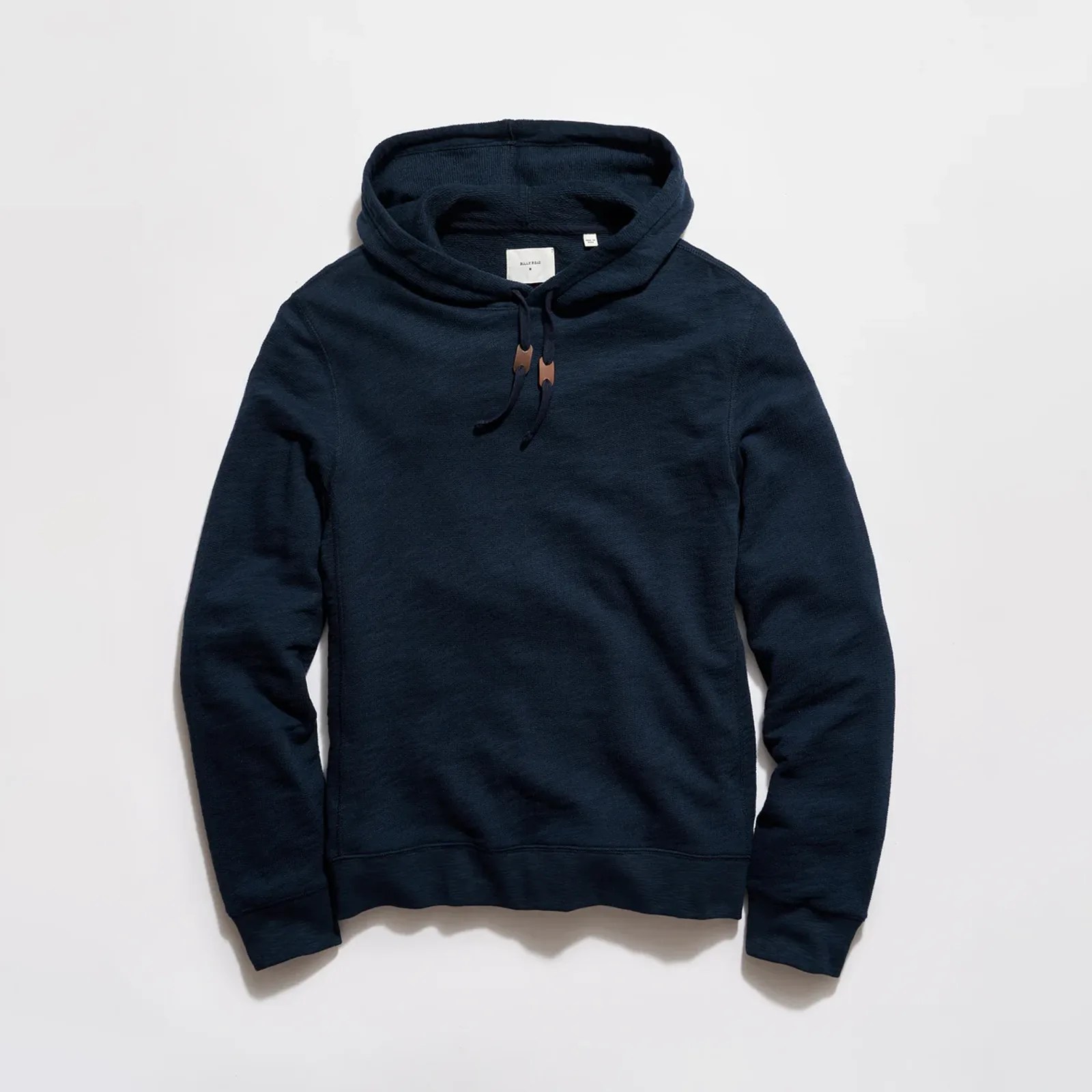 Navy blue hooded sweatshirt with drawstrings and ribbed cuffs laid flat on a white surface.