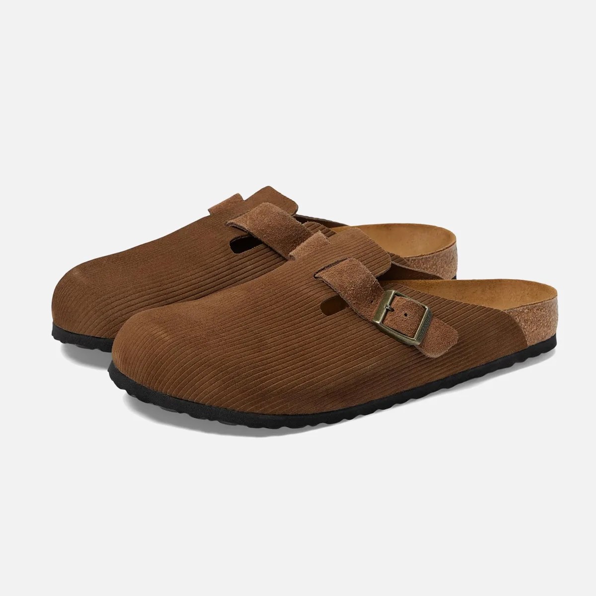Pair of brown suede slip-on clogs with ribbed texture, adjustable buckle strap, and black soles.